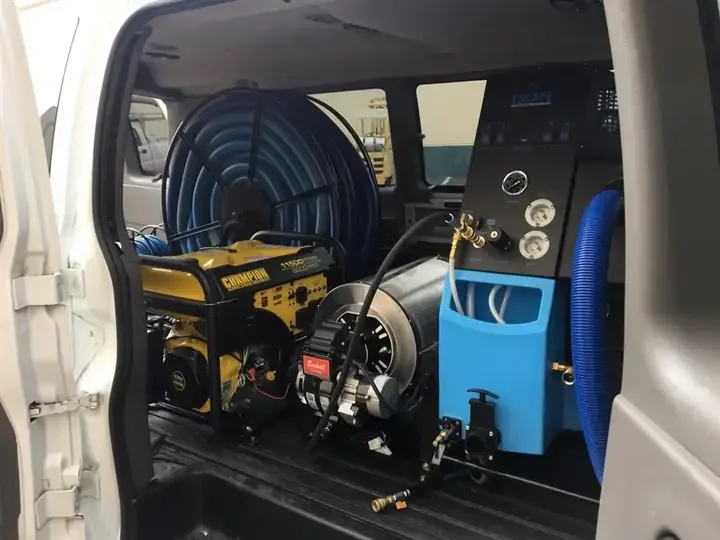 Truck-mounted extraction unit and hose reel loaded in a work van